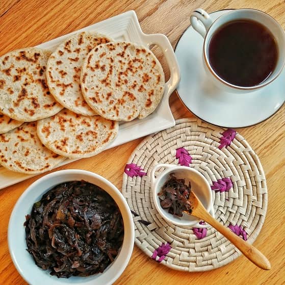 Coconut roti and Seeni sambal(Caramelized onion relish) on a table with Ceylon black tea.