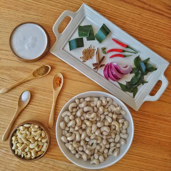 Ingredients- cashew nut, coconut milk and spices on a table.