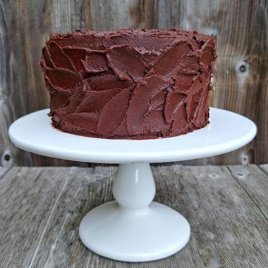 Devi'ls food cake/ chocolate cake on a white cake stand.