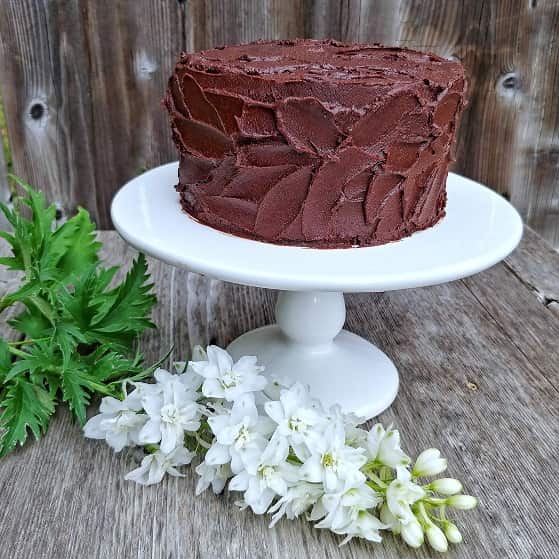 Devil's food cake on display with fresh white flowers.