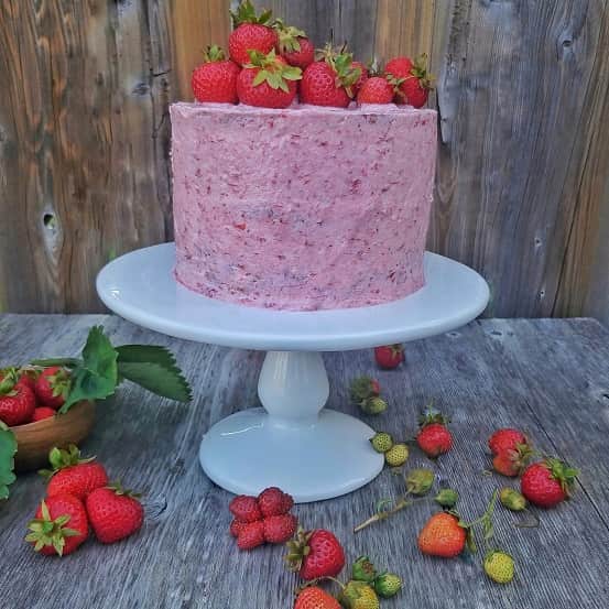Strawberry cake decorated with Strawberries on the top and around.