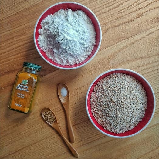 Wheat flour, Black Gram, turmeric , fenugreek seed and salt on a table.