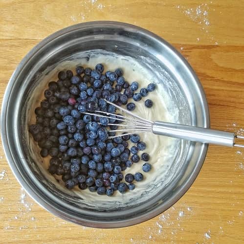 A bowl of muffin batter with fresh blueberries.
