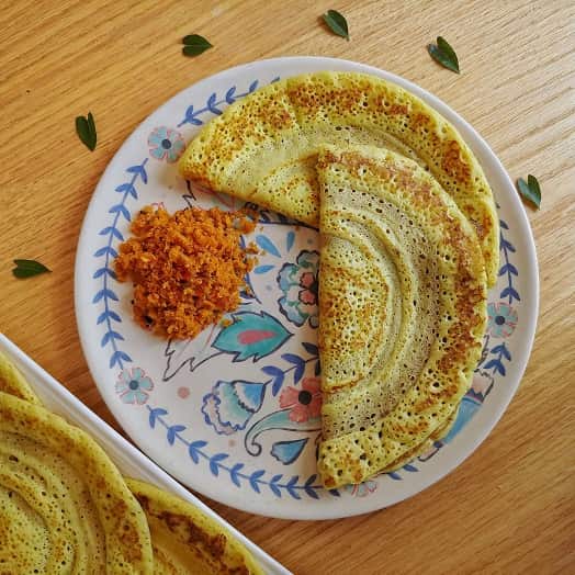 Dosa and coconut sambol on a plate.