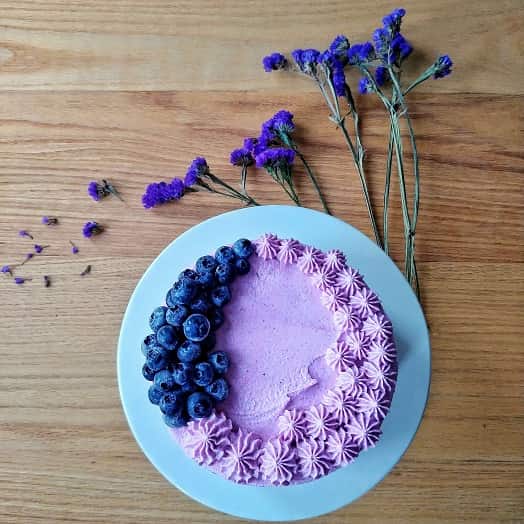 Blueberry Cashew Nut Cake on a table with statice dried flowers.