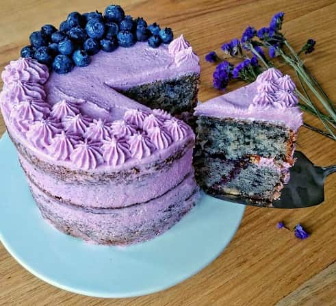 Blueberry Cashew Nut Cake with a sliced cake piece on a table.